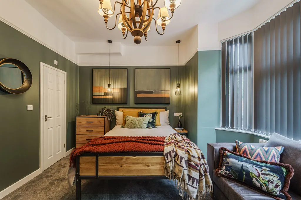 A bedroom with a bed and a couch in it.